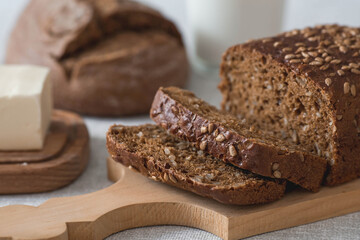 Fresh delicious whole grain rye bread with seeds close-up. Freshly baked bread on a wooden board. The context of a bakery with delicious bread. Confectionery products.