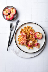 Maple bacon waffles. Belgian sweet and savoury waffles with bacon, apples and maple syrup. Served breakfast, brunch on light background