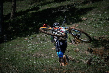person climbs on a hill with a bike