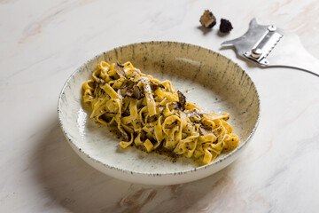 tagliatelli pasta with black truffle on marble table