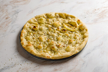 focaccia with oregano and olive oil on white marble table