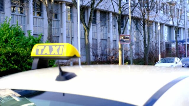 defocused car with sign Taxi waits for passengers on street Helsinki city, public transport concept used to transport passengers to point with payment taximeter, Frankfurt, Germany, selective focus