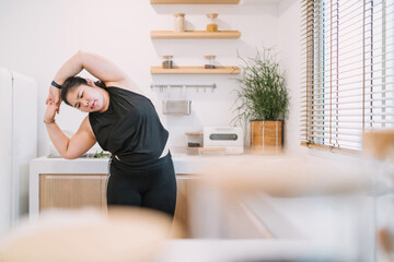 chubby woman stretching arms improve movement. relax fat woman training home fitness trying...