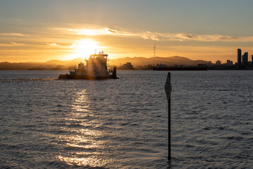 Obraz premium tugboat in front of sunset over bay