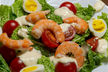 Salad with tomatoes, sauce, quail eggs and shrimps