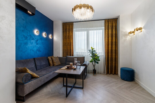 A modern living room interior of a luxurious hotel apartment with a designer couch, and art decorations. Real photo.