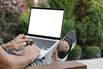 a man works in nature, sitting in a chair with a laptop