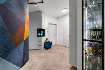 Entrance to a bright modern apartment with a large blue fresco on the wall