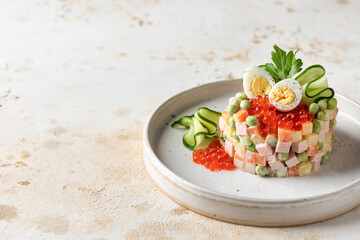 Russian traditional salad Olivier with vegetables, sausage and mayonnaise. Winter salad in ring form on a light brown textured background with text space