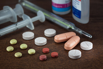 Group of different medical pills and capsules on the dark table close-up