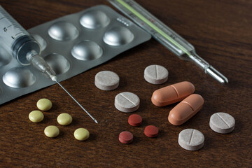 Group of different medical pills and capsules on the dark table close-up