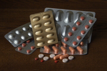 Group of different medical pills and capsules on the dark table close-up