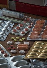 Group of different medical pills and capsules on the dark table close-up