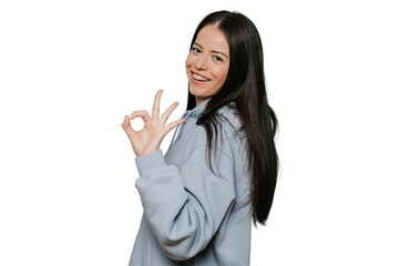 Long haired young brunette caucasian woman dressed in pastel lilac hoodie shows ok gesture, broad smiling over transparent background with satisfied expression. Promo and sales template.