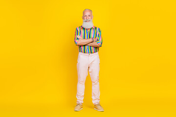 Portrait of handsome optimistic good mood old man long beard wear colorful shirt hold arms folded isolated on yellow color background