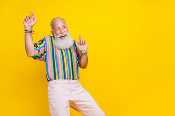 Fototapeta Photo of funky good mood man wear colorful shirt rising having fun pointing fingers up empty space isolated yellow color background obraz