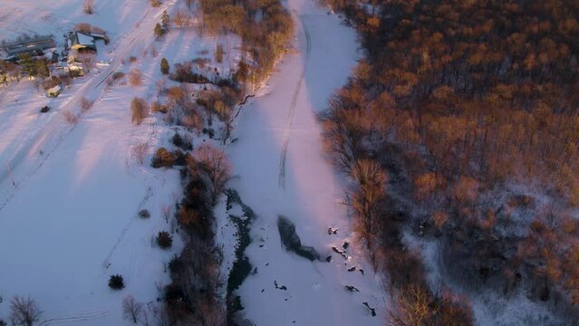 Snowy Winter Sunset Drone Video Above a River
