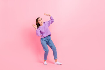 Fototapeta na wymiar Full length photo of dreamy excited lady wear violet sweater rising arms looking up empty space isolated pink color background