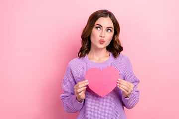 Photo of tender lovely lady blow lips wear stylish outfit hold paper card interested look empty space isolated on pink color background