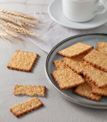 Wholegrain cookies on a plate, on a table with cup of coffee. Selective focus