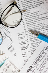 Close-up of US individual tax form, receipts, and pen. Filling taxes