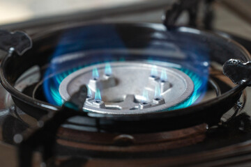 Portable kitchen gas stove with a burning blue flame