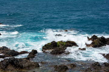 Fototapeta na wymiar Lava stones in the surf