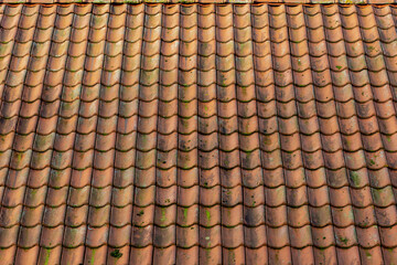 Red tiles background details, Old orange roof brick under the sunlight, Shingles texture with green moss, Roof top material, Abstract geometric pattern