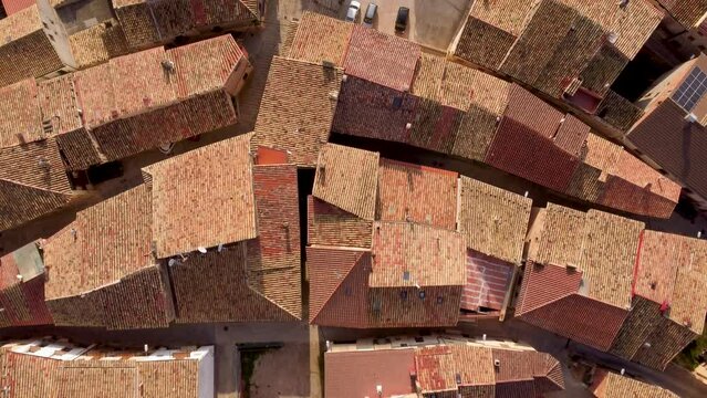 4k drone top view flight over old red rooftops, a church, and a lovely cemetery of an ancient small village in Spain