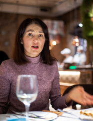 emotional beautiful brunette girl in a lilac sweater in a cafe. A party
