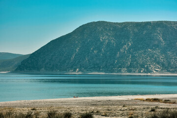 Fototapeta na wymiar Beach of Salda Lake, in Burdur Turkey.A woman sunbathing on the beach.The lake sedimentary records show high resolution climate changes that are related to solar variability during the last millennium