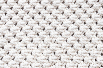 Knitwear background. White woolen fabric texture. Warm jumper closeup. Yarn textile backdrop. Handmade sweater texture. Cotton pattern.