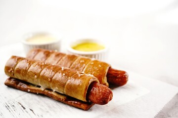 Pretzel hot dogs served with sauce, selective focus - Game day snacks