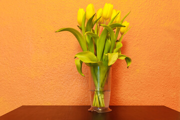 Bouquet of yellow tulips in a vase on a table