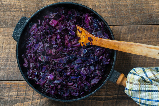 Red cabbage are pan-fried until lightly charred, then braised in mulled wine. Background of fry blue cabbage in a section, macro. Closeup, top view. Texture and pattern of purple cabbage