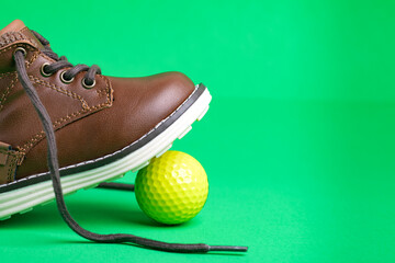 children's shoe and ball on a green background, close-up. Space for text.