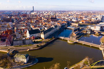 Fototapeta na wymiar Picturesque aerial view of Wroclaw on Oder River bank overlooking historical Market Square with Old Town Hall, massive Gothic church of St. Elizabeth and St. Mary Magdalene Church in spring, Poland