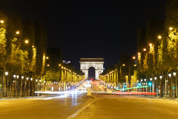 The Arc de Triomphe at night seen across des Champs-Élysées avenue in Paris, Francja