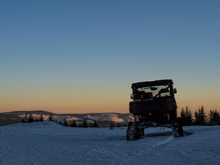 Tracked UTV in the snow during sunset