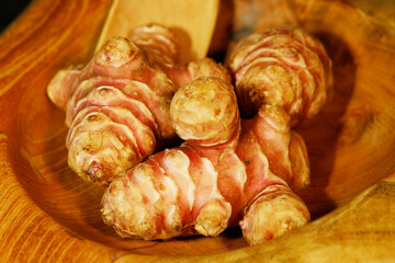 Unpeeled and raw Jerusalem artichokes or Topinambur on a table