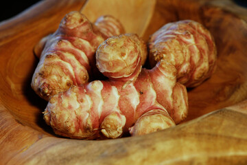 Unpeeled and raw Jerusalem artichokes or Topinambur on a table