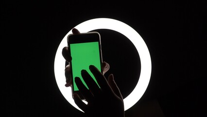 female hands show the phone close-up on a black background. green screen mockup for advertising insert. Moves fingers across the screen, taps, swipes, types
