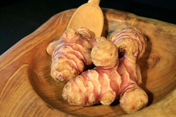 Unpeeled and raw Jerusalem artichokes or Topinambur on a table