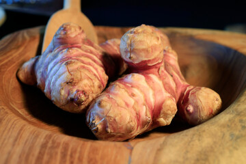 Unpeeled and raw Jerusalem artichokes or Topinambur on a table