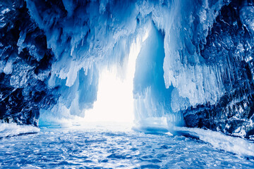 Mysterious blue ice cave or grotto on frozen lake Baikal. Concept adventure Amazing landscape
