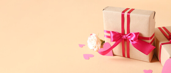 Gift boxes, rose flower and paper hearts on beige background with space for text. Valentine's Day celebration