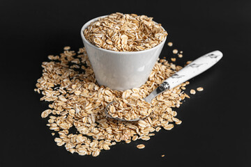 Bowl of raw oatmeal on dark background