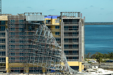 Aerial view of ruined by hurricane Ian construction scaffolding on high apartment building site in...