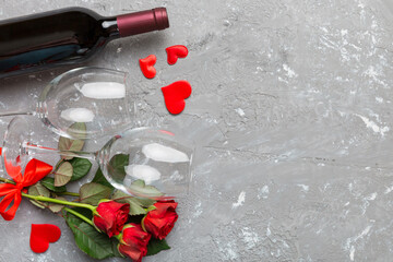 Valentine's day composition with red wine, rose flower and gift box on table. Top view, flat lay....