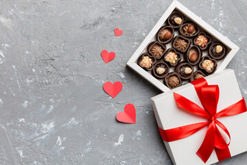 Delicious chocolate pralines in red box for Valentine's Day. Heart shaped box of chocolates top view with copy space